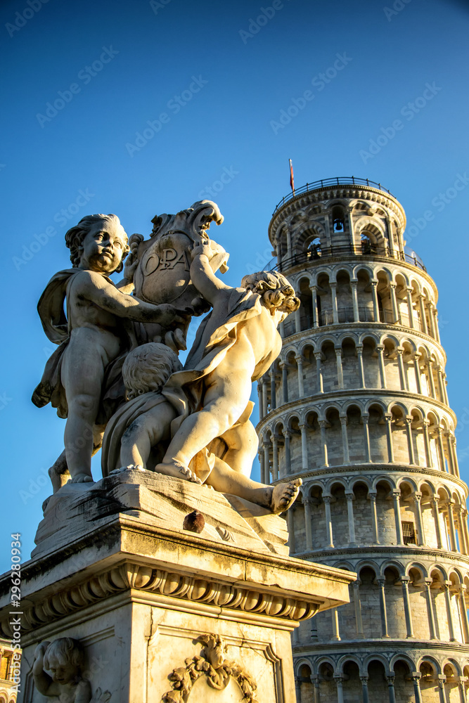 Wall mural The putti in front of the leaning tower of Pisa at sunset