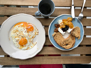 Homemade Turkish Style Breakfast with Fried Eggs, Cheese, Bread and Jam / Marmalade served with Filtered / Filter Coffee on Wooden Table.