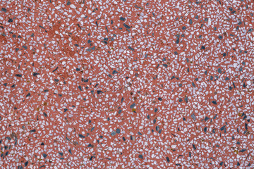 Stone chips in red cement abstract background with copy space