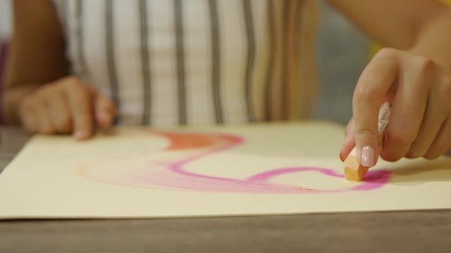 woman paints a picture on a white sheet. picture of flamingo