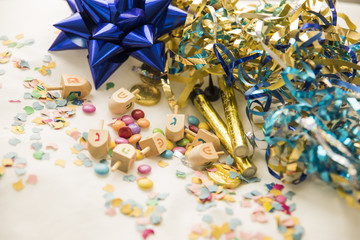 Fototapeta na wymiar Dreidels and candies near confetti and tinsel
