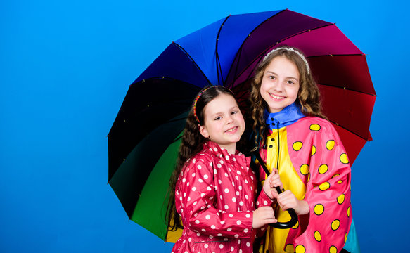 cheerful hipster children, sisterhood. rain protection. Rainbow. autumn fashion. happy little girls with colorful umbrella. family bonds. Little girls in raincoat. Important part of camping