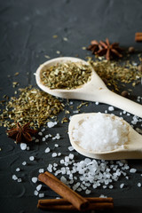  Wooden spoon with Italian seasoning-dried oregano with thyme,vegetables.Oregano in a wooden spoon on a rocky concrete dark black background with a place for text Top view