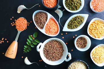 Composition of dry legumes. Assortment of colorful legumes in bowls. Lentils, Moth beans, Mung Beans, Masoor or red lentils, Split Chickpea, Toor Dal, Raw Split Mung Bean Lentils, Yellow Split.