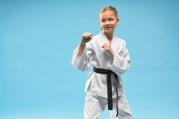 Karate girl in defense position, practicing combat sports.
