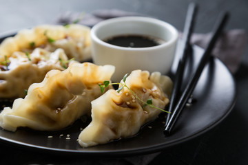 Wonton stuffed with soy sauce on a dark table
