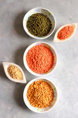 Composition of dry legumes. Assortment of colorful legumes in bowls. Lentils, Moth beans, Mung Beans, Masoor or red lentils, Split Chickpea, Toor Dal, Raw Split Mung Bean Lentils, Yellow Split.
