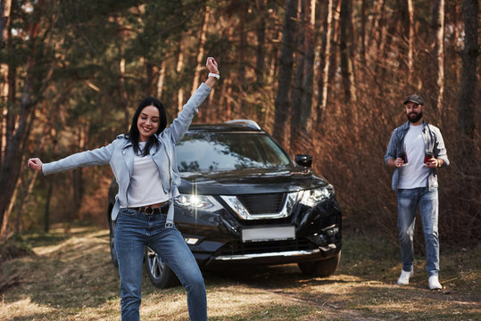 Feeling Free. Enjoying The Nature. Couple Have Arrived To The Forest On Their Brand New Black Car