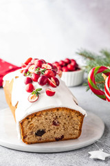 Christmas cake with cranberries and Christmas decorations on a gray background.