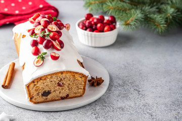 Christmas cake with cranberries and Christmas decorations on a gray background.