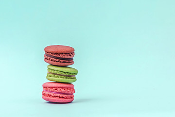 Assorted colorful macaroons on mint green background with copy space.