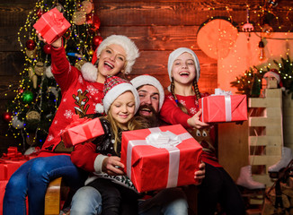 Obraz na płótnie Canvas Christmas tradition. Family bonding activities. Christmas joy. Happy holidays. Parents and children opening christmas gifts. Father Santa claus and mother little daughters christmas tree background