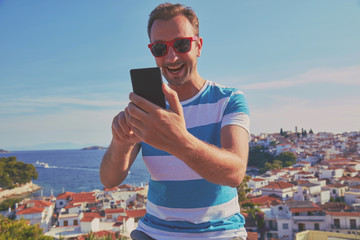 Modern man using cellphone and enjoying the view.