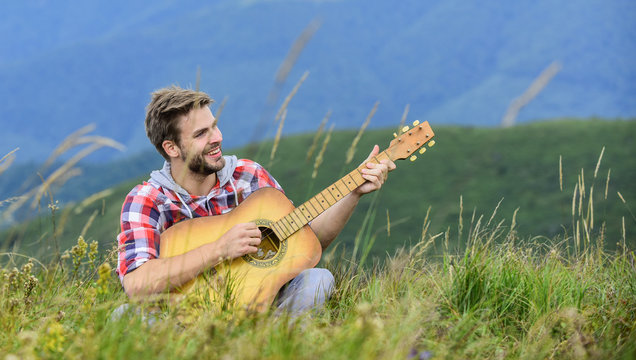 Keep a Song In Your Heart. sexy man with guitar in checkered shirt. hipster fashion. western camping and hiking. happy and free. cowboy man with acoustic guitar player. country music song