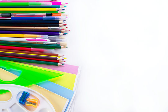 A lot of multi-colored school and office supplies on a white background. Back to school. Copyspace for text