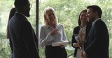 Cheerful old and young multiracial colleagues laughing standing in office