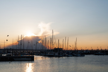 Naklejka premium Wonderful romantic sunset at Adriatic sea in Gabicce, Italy. Boats and yachts in harbour under a colorful cloudy sky.