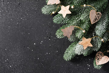 Christmas or New year holiday background with fir branches and wooden decorations. Top view with copy space