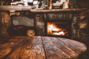 Table top with blurred fireplace and cosy home interior background.