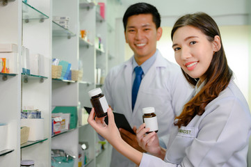 woman pharmacist and doctor in charge of checking inventory list of medicine remaining or balance in stock, working together in pharmacy drug store