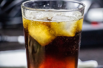 Whiskey with ice in a glass close-up. Grapes with cheese and pita bread in a plate.