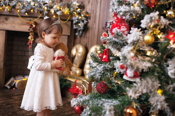 child adorns the Christmas tree
