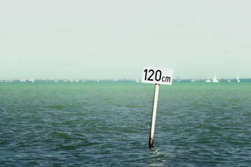 Caution sign in the Lake Balaton, water depth 120 cm. Minimalistic photo of a warning sign for...