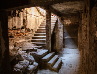 Old abandoned tunnel in the slum underground cellar. Entrance to urban catacombs. Underside of city...