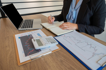 Business women are planning business investments related to shares By analyzing and calculating the...