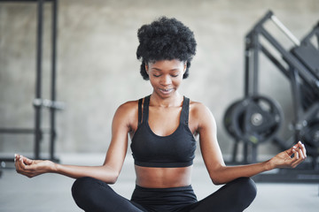 Naklejka na ściany i meble Calm mind. African american woman with curly hair and in sportive clothes have fitness day in the gym