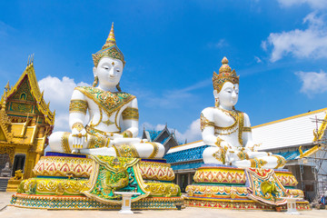 Obraz premium White and golden Buddha Statue with the church in blue sky background at Wat Charoen Rat Bamrung (Wat Nong Pong Nok) in Nakhon Pathom Province, Thailand