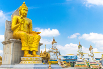 Big Golden Buddha Statue with Tree Smaller White Buddha Statue in blue Sky Background at Wat Charoen Rat Bamrung (Wat Nong Pong Nok) in Nakhon Pathom Province, Thailand