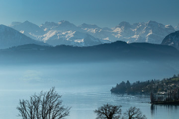 Fototapeta na wymiar Morning fog above the Luzern lake with mountains