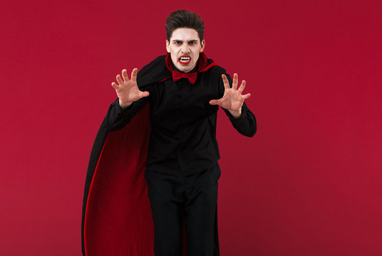 Image of evil vampire man in black halloween costume frightening