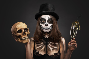 Halloween girl with skull makeup for Halloween on a black background