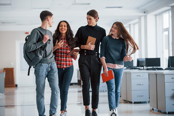 Obraz premium Conception of business and success. Group of young people walking in the office at their break time
