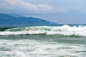 Big breaking wave on a sandy beach in Da Nang, Vietnam