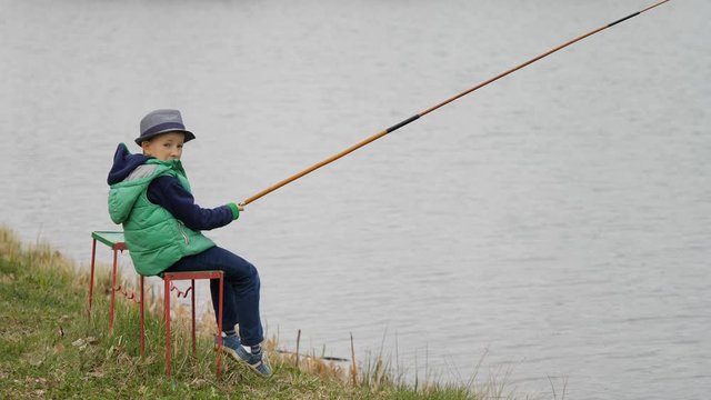 Kid with fishing rod relaxing in the nature