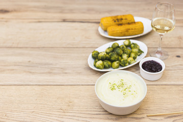 Grilled corns with glass of wine on wooden table