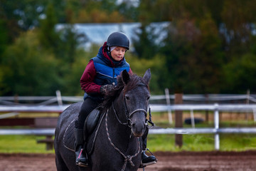 A little boy riding a horse safely