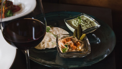 Hummus chickpea with marinated cucumber and pita bread, close-up. Dinner at restaurant.