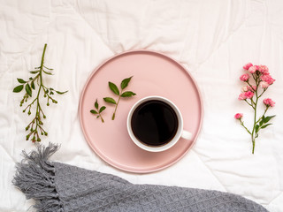 Eine Tasse Kaffee auf einem rosa Serviertablett auf einer weißen Bettdecke, Frühstück, Blume