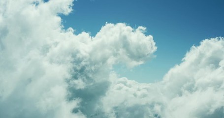 Aerial drone view flying forward through a sunny cloudscape mid day with blue skies, view from the front of an airplane, travel airlines freedom concept, cloudscape background