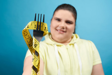 Close up of fork wrapped by measuring tape holding by girl