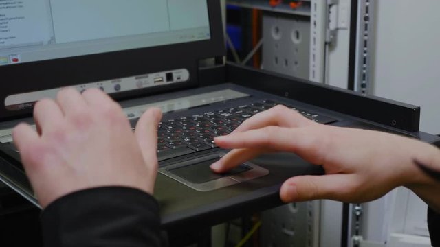technician takes laptop and checks system in server room