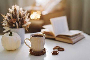 Autumn still life. Coffee cup, flowers, book and pumpkin. Hygge lifestyle, cozy autumn mood. Flat lay, Happy thanksgiving 