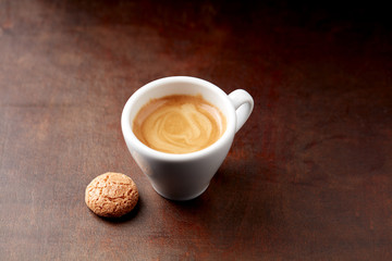Cup of coffee with amaretti (Italian biscuits) on rustic wooden background. Copy space.
