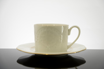 White coffee cup with plate on black table