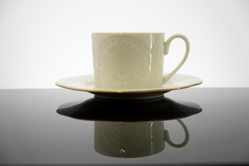 White coffee cup with plate on black table