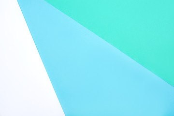 Abstract geometric background of white, green and blue pastel cardboard. Copy space for your text.